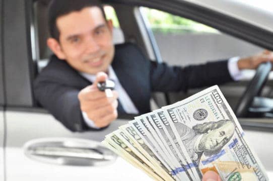 man exchanging keys to car for cash
