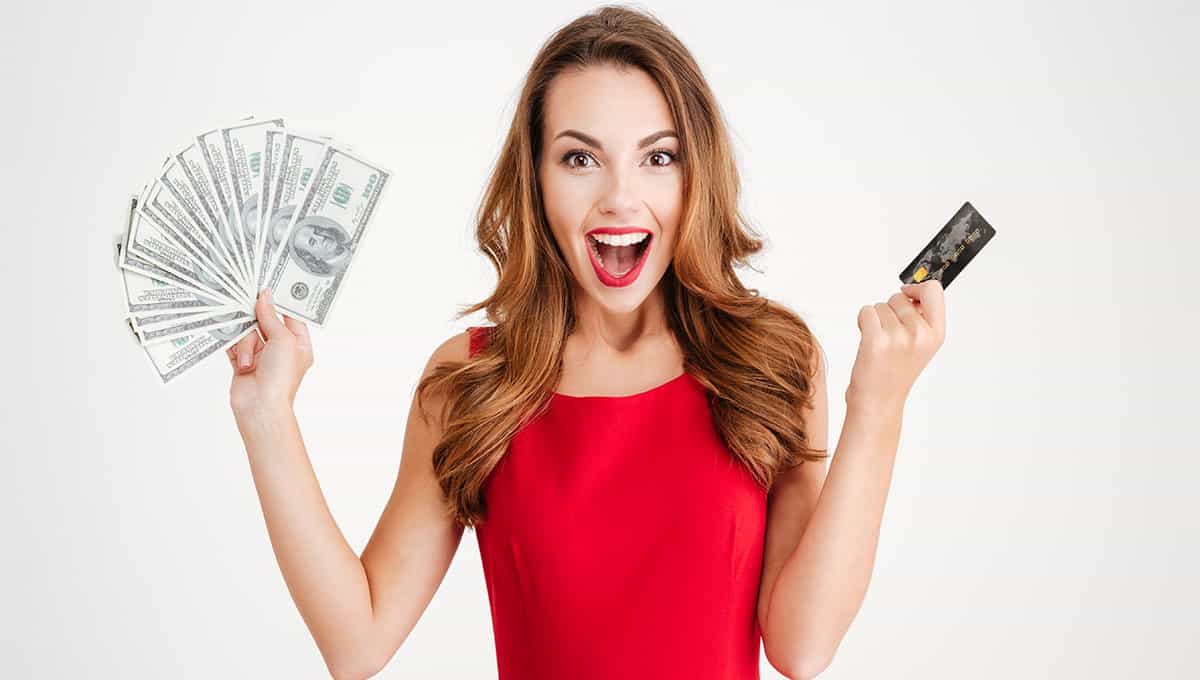 excited woman holding cash and credit card