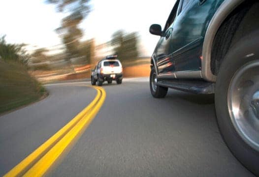 two cars going fast on a curved road