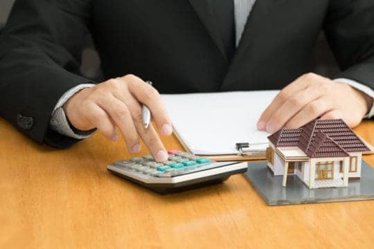 Mortgage loan officer calculates costs on a residential home loan during the underwriting and approval process