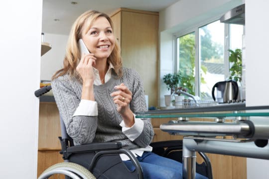 Woman in a wheelchair calling to ask about disability forgiveness for credit card debt