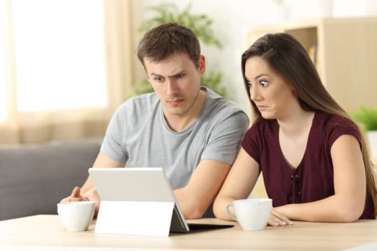 Couple looking at confusing financial information online