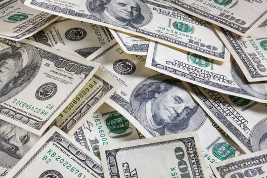 debt settlement vs. debt management. Set of 100 dollar bills as background for money theme.