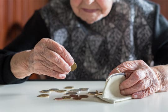 Because of unequal pay an Elderly woman counting money. unequal pay affects women's retirement in a bad way.