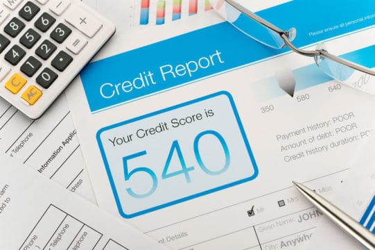 Credit report with score on a desk representing credit score stories that are troubling.