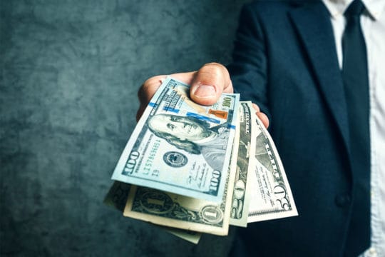 Businessman from bank offering money loan in USA dollar banknote