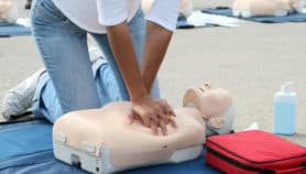 Female instructor showing CPR on training doll