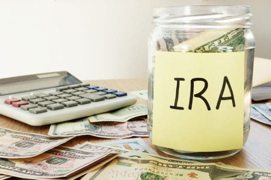 IRA written on a stick and jar with dollars