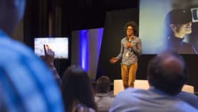 Male speaker on stage talking to audience