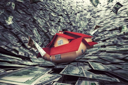 Real estate market crisis with a house sucked into debt