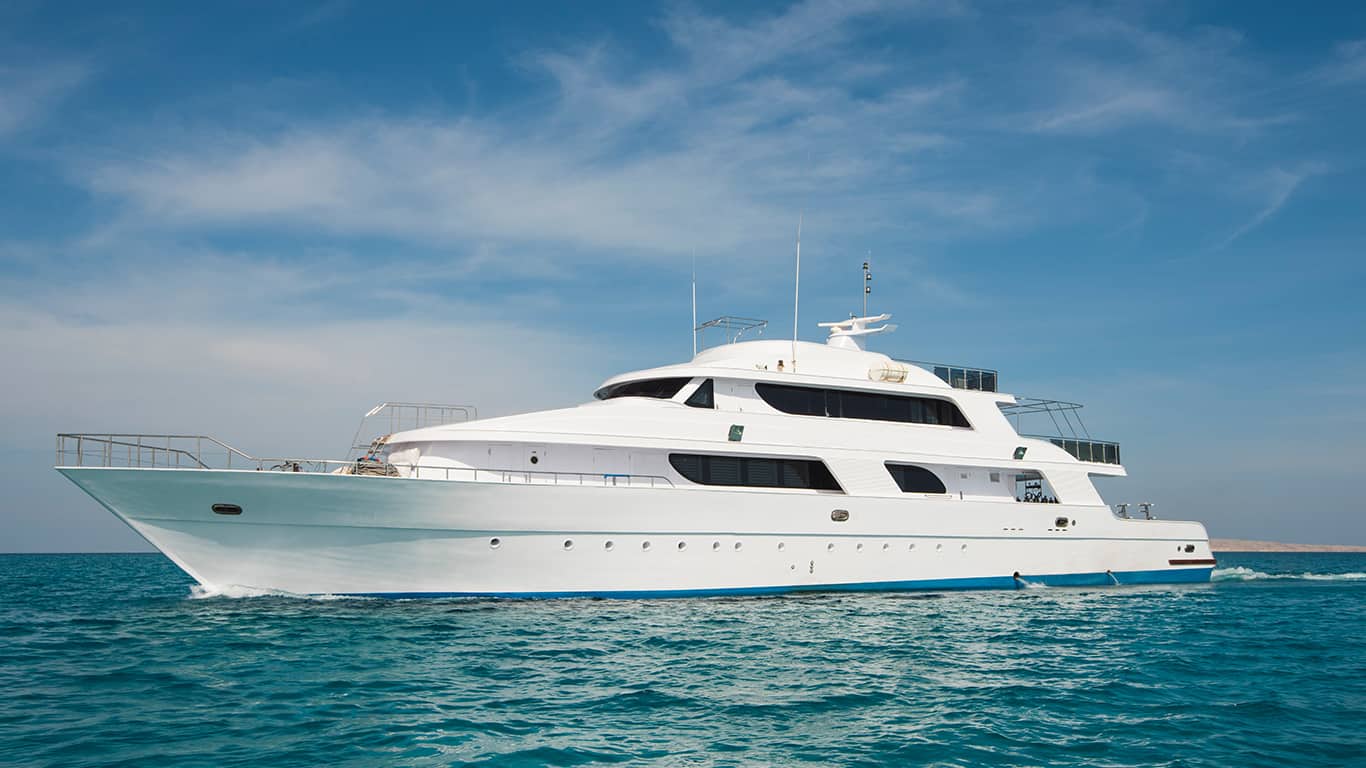 A luxury private motor yacht under way on tropical sea with bow wave