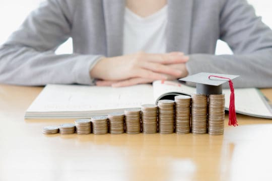 grants to pay off student loans; Businesswoman saving education coins