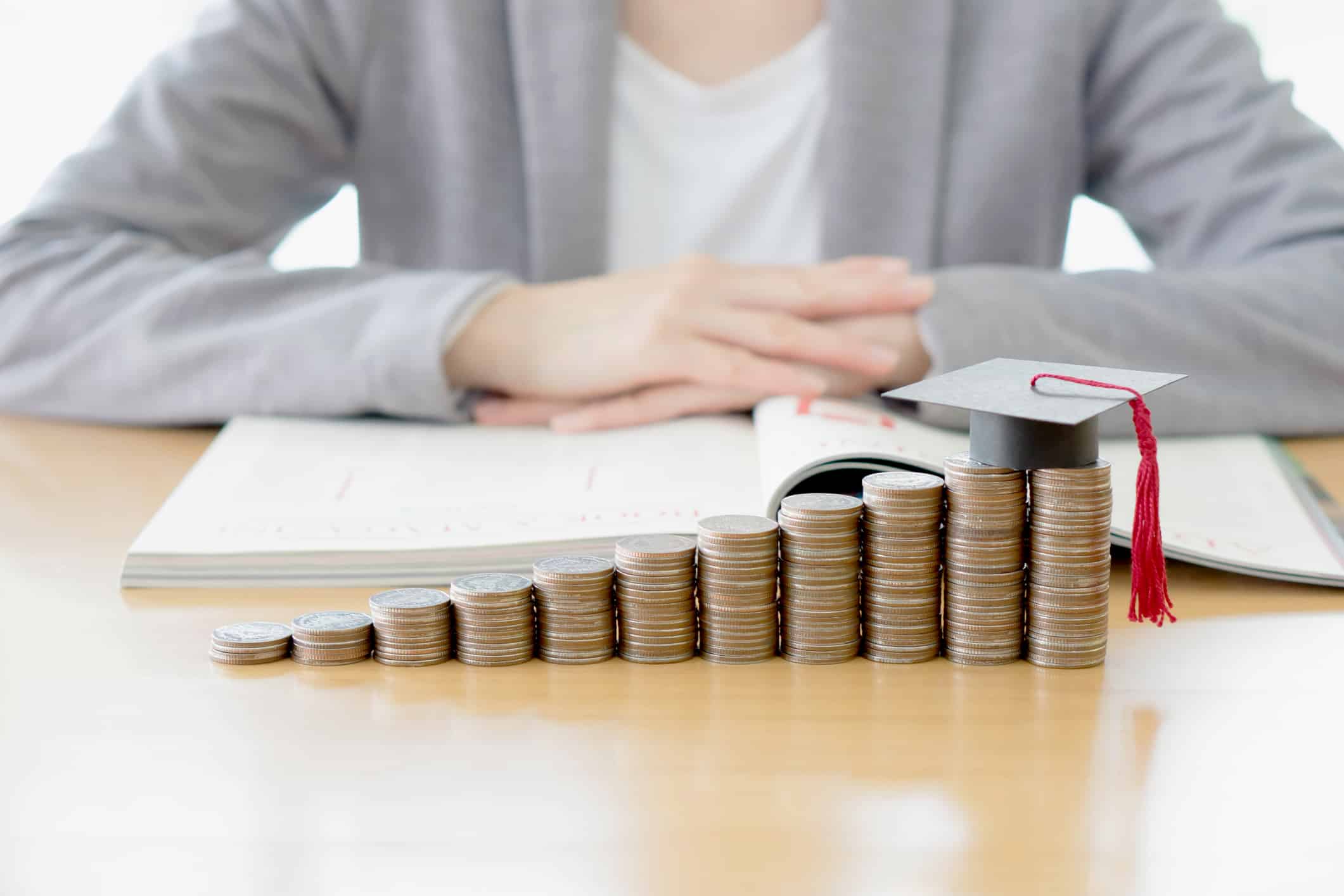 grants to pay off student loans; Businesswoman saving education coins