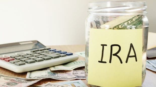 IRA written on a stick and jar with dollars.