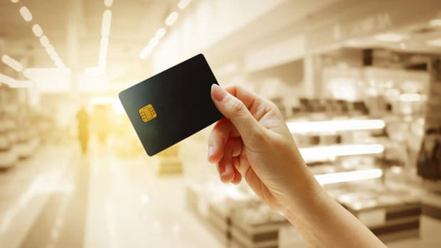 hand holding credit card with blur store background