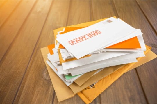 A pile of mail with past due notifications