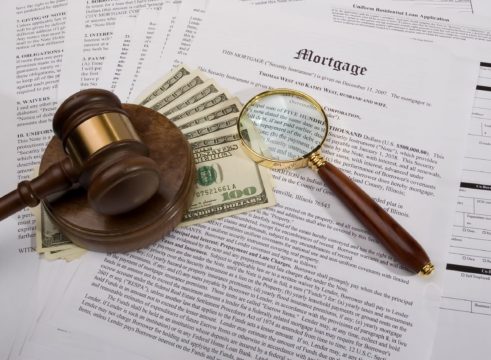 fixed rate mortgage guide; money, gavel, and magnifying glass on top of mortgage papers
