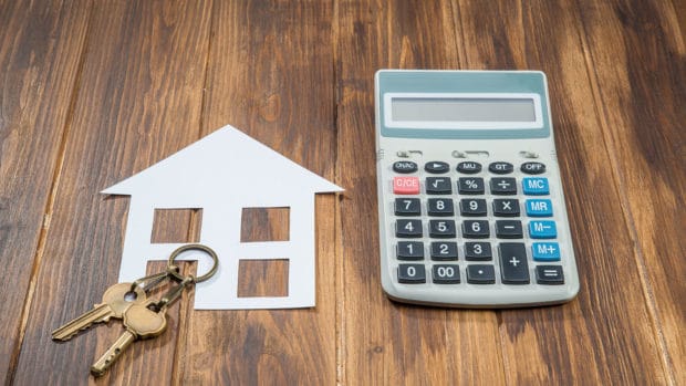 House and key with Calculator on wooden background