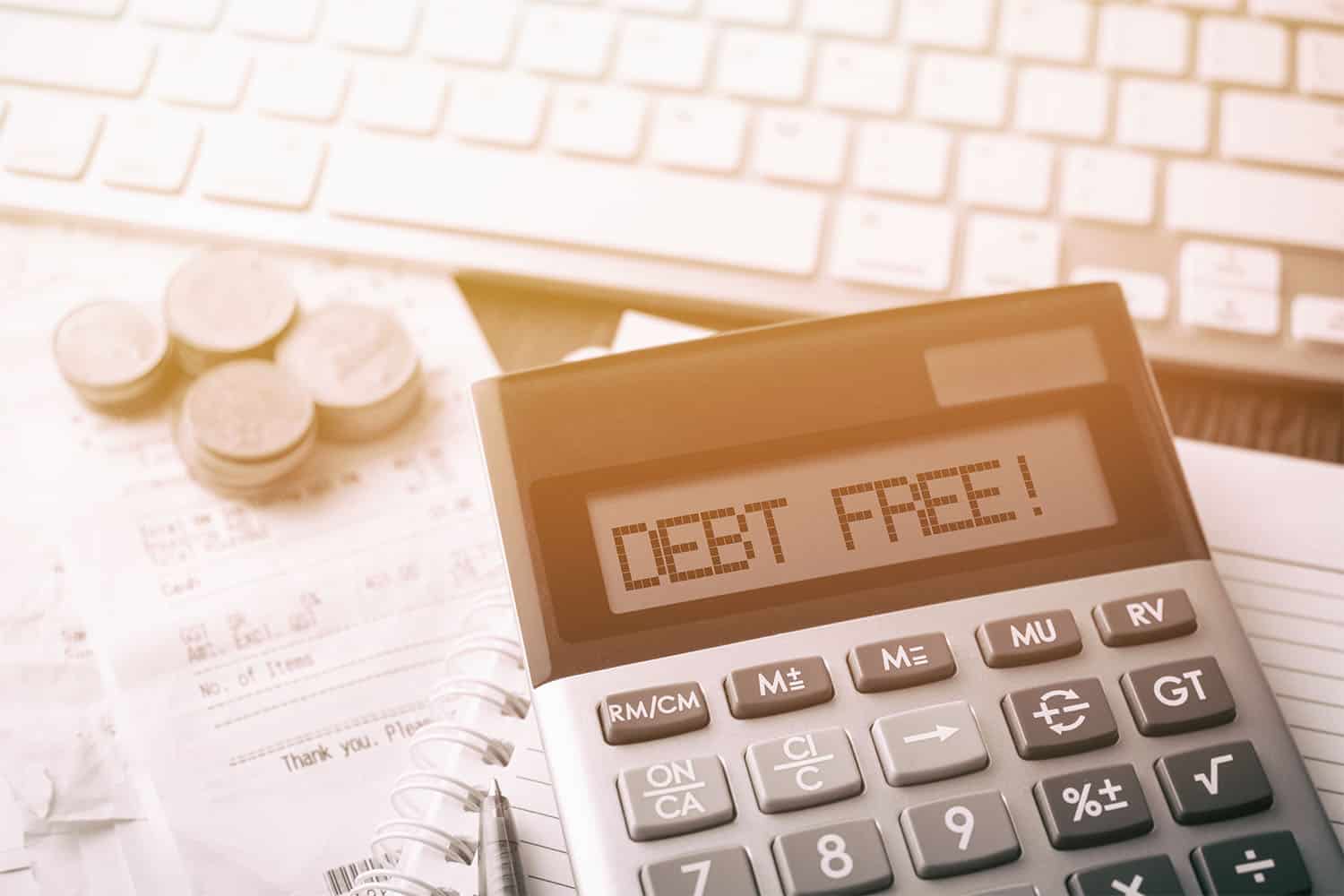 Image of calculator on a desk showing the words "debt-free"