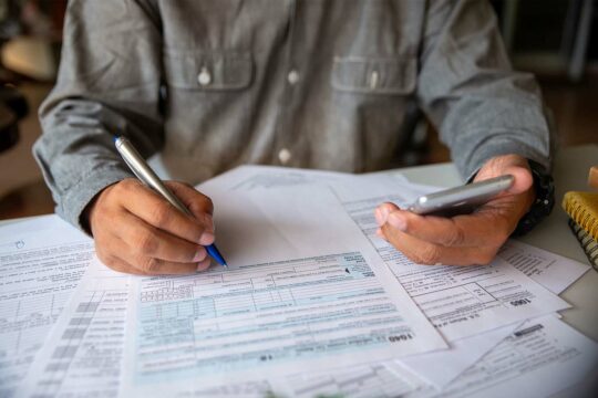 A business owner in a partnership fills out IRS form 1040 and 1065 for his small business taxes
