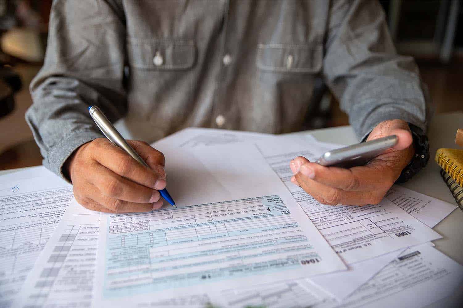 A business owner in a partnership fills out IRS form 1040 and 1065 for his small business taxes