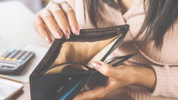 Asian woman hand open empty purse looking for money