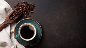 Coffee cup and beans on old kitchen table