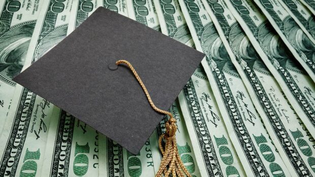 Graduation cap on assorted hundred dollar bills