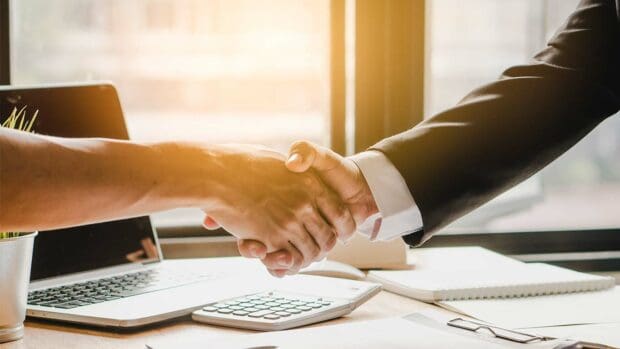 Real estate agent and customers shaking hands together