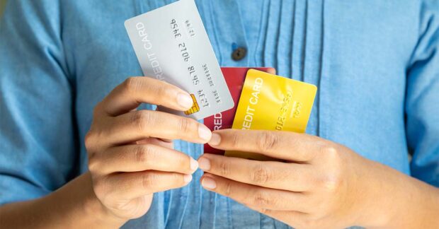 Woman holding several credit cards and he is choosing a credit card to pay and spend Payment for goods via credit card. Finance and banking concept.