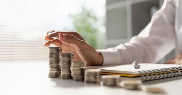 Young Asian woman making stack of coin