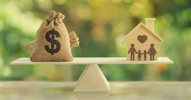 House model, loan bag on basic balance scale, depicts saving for a house or flat manageable and turn a home buying dream into reality